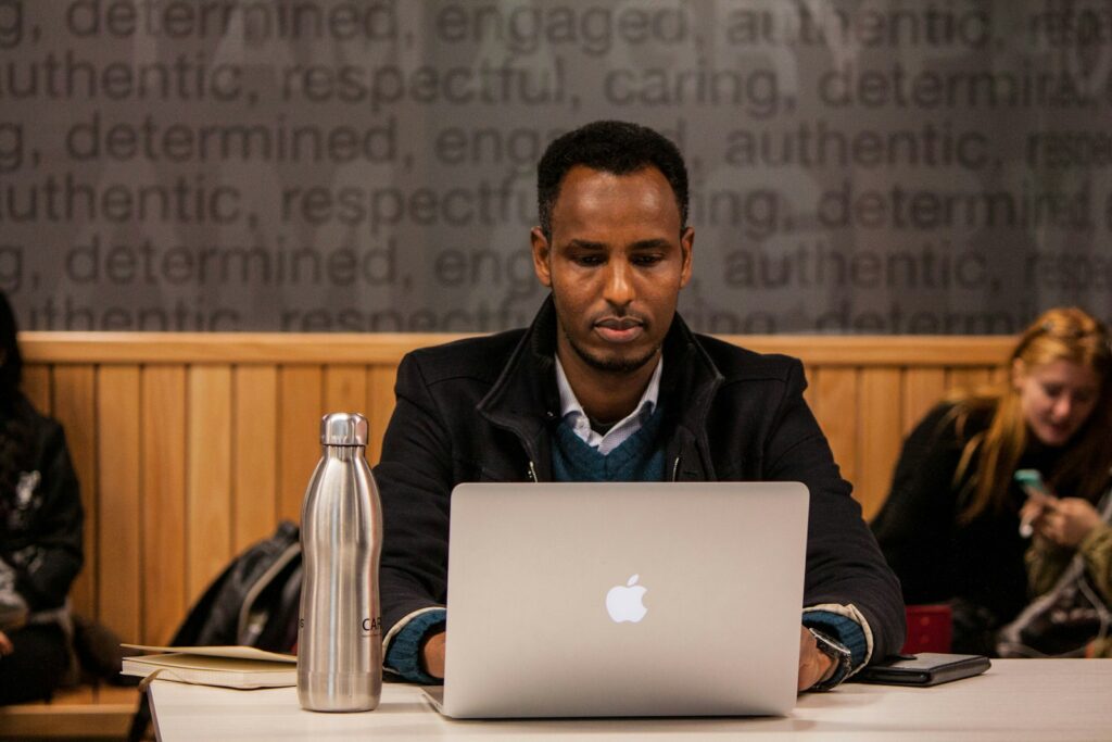 Homme utilisant un MacBook sur une table